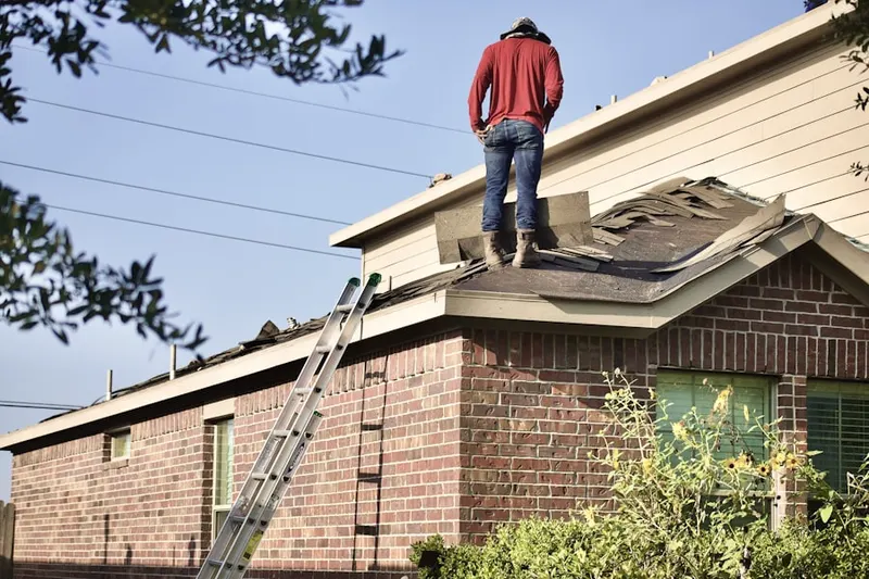 Professional roofer working on a residential roof in Giants Neck